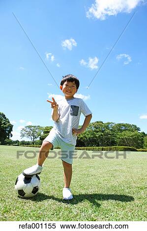 Japanese young boy playing soccer in a city park View Large Photo Image Stock Photography - Japanese young boy playing soccer in a city park. Fotosearch
