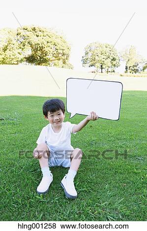 Stock Photo - Japanese young boy with whiteboard in a city park. Fotosearch