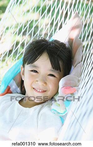 Japanese young girl on hammock in a city park View Large Photo Image Stock Image - Japanese young girl on hammock in a city park. Fotosearch