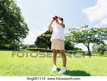 Japanese young girl with binoculars in a city park View Large Photo Image Picture - Japanese young girl with binoculars in a city park. Fotosearch