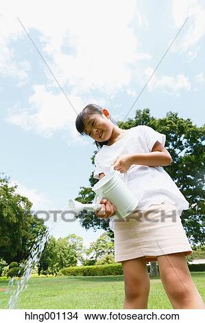 Japanese young girl with watering can in a city park View Large Photo Image Picture - Japanese young girl with watering can in a city park. Fotosearch