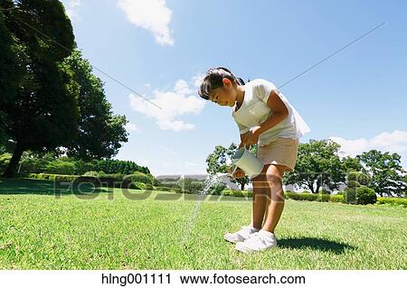 Japanese young girl with watering can in a city park View Large Photo Image Stock Image - Japanese young girl with watering can in a city park. Fotosearch