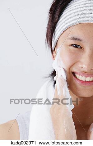 Stock Image - Portrait of young man doing skin care. Fotosearch