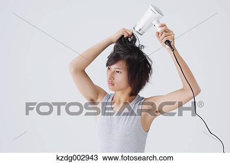 Portrait of young man drying his hair View Large Photo Image Stock Image - Portrait of young man drying his hair. Fotosearch