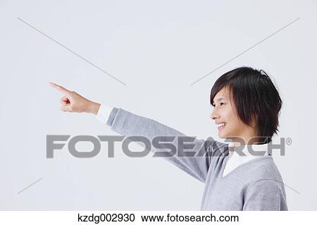 Stock Image - Portrait of young man pointing a finger. Fotosearch