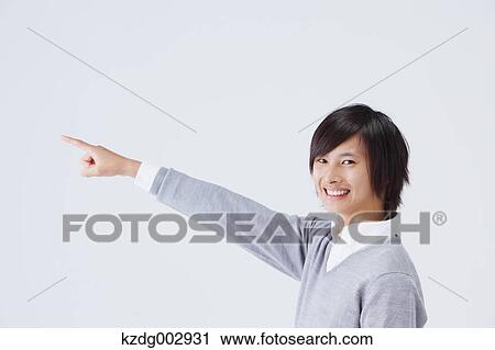 Stock Image - Portrait of young man pointing a finger. Fotosearch