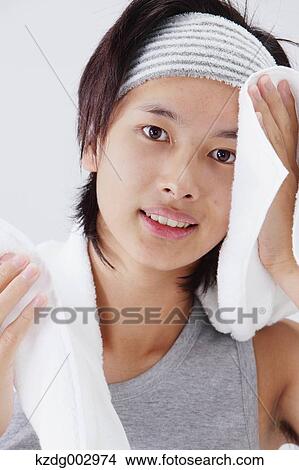 Picture - Portrait of young man wiping his face. Fotosearch