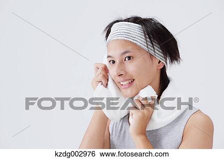 Stock Photograph - Portrait of young man wiping his face. Fotosearch