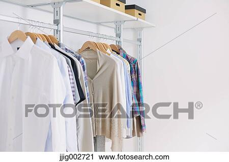 Shirts and sweaters hanging in a walk in closet View Large Photo Image Stock Image - Shirts and sweaters hanging in a walk in closet. Fotosearch