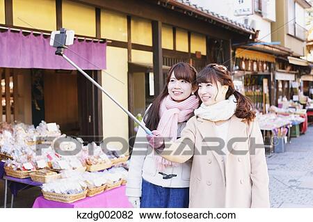 "Two young Japanese women taking a selfie in Kawagoe old town, Japan" View Large Photo Image Stock Image - "Two young Japanese women taking a selfie in Kawagoe old town, Japan". Fotosearch