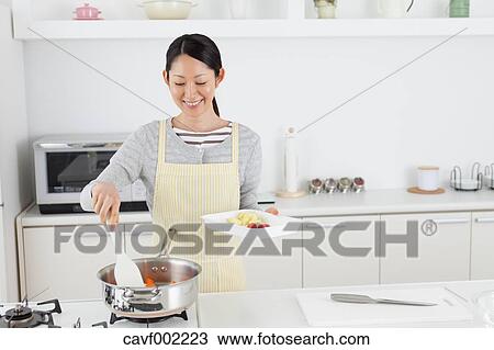 Woman cooking in an open kitchen View Large Photo Image Stock Image - Woman cooking in an open kitchen. Fotosearch