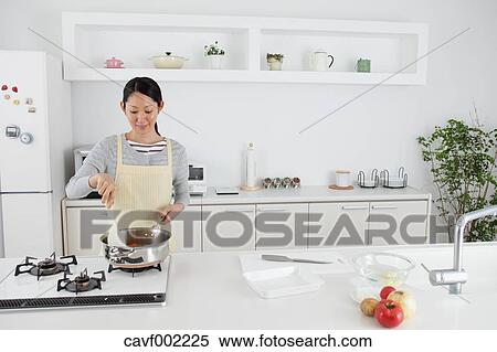 Woman cooking in an open kitchen View Large Photo Image Stock Photography - Woman cooking in an open kitchen. Fotosearch