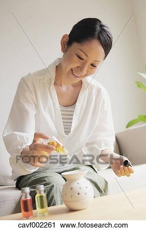Woman pouring essence oil in a pot View Large Photo Image Stock Image - Woman pouring essence oil in a pot. Fotosearch