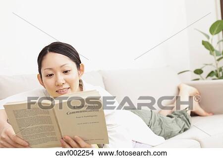 Woman reading a book on the sofa View Large Photo Image Picture - Woman reading a book on the sofa. Fotosearch