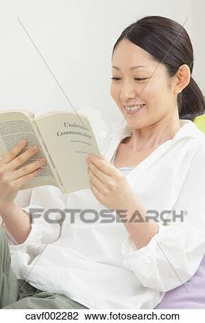 Woman reading a book on the sofa View Large Photo Image Stock Image - Woman reading a book on the sofa. Fotosearch