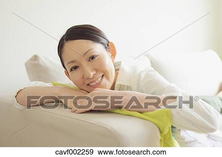 Woman relaxing on the sofa View Large Photo Image Stock Photo - Woman relaxing on the sofa. Fotosearch