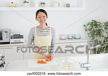 Woman slicing carrots with a kitchen knife View Large Photo Image Stock Photograph - Woman slicing carrots with a kitchen knife. Fotosearch