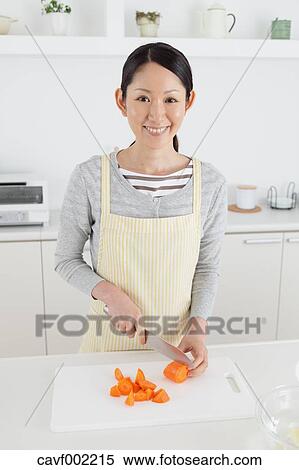 Stock Photography - Woman slicing carrots with a kitchen knife. Fotosearch