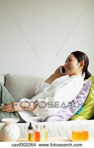 Woman using a Smartphone on the sofa View Large Photo Image Picture - Woman using a Smartphone on the sofa. Fotosearch