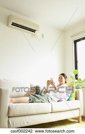 Woman using a Smartphone on the sofa View Large Photo Image Stock Image - Woman using a Smartphone on the sofa. Fotosearch