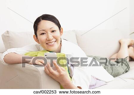 Woman using a Smartphone on the sofa View Large Photo Image Stock Image - Woman using a Smartphone on the sofa. Fotosearch