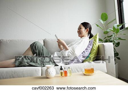 Woman using a Smartphone on the sofa View Large Photo Image Stock Image - Woman using a Smartphone on the sofa. Fotosearch