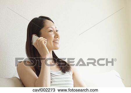 Woman using a Smartphone on the sofa View Large Photo Image Stock Image - Woman using a Smartphone on the sofa. Fotosearch