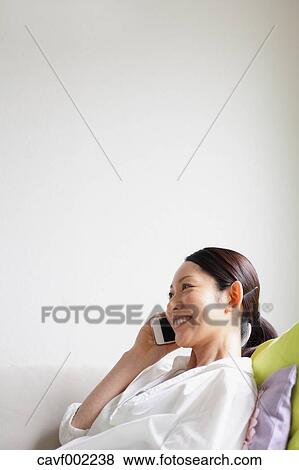 Woman using a Smartphone on the sofa View Large Photo Image Stock Photo - Woman using a Smartphone on the sofa. Fotosearch