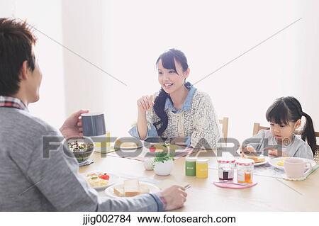 Young adult couple and their daughter having breakfast in their dining room View Large Photo Image Picture - Young adult couple and their daughter having breakfast in their dining room. Fotosearch