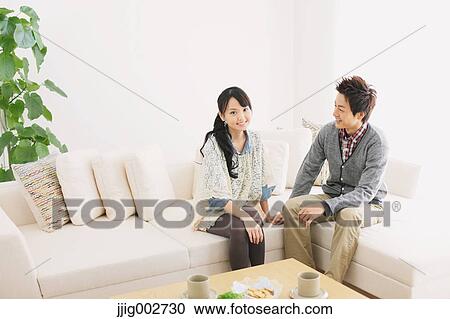 Young adult couple relaxing on the sofa View Large Photo Image Stock Image - Young adult couple relaxing on the sofa. Fotosearch