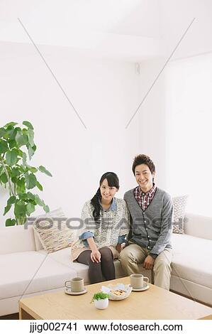 Young adult couple relaxing on the sofa View Large Photo Image Stock Image - Young adult couple relaxing on the sofa. Fotosearch