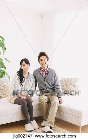 Young adult couple relaxing on the sofa View Large Photo Image Stock Photo - Young adult couple relaxing on the sofa. Fotosearch