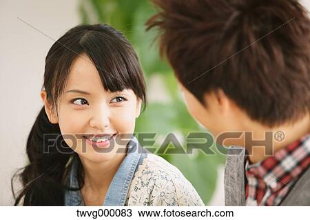Young adult couple smiling and looking at each other View Large Photo Image Stock Image - Young adult couple smiling and looking at each other. Fotosearch