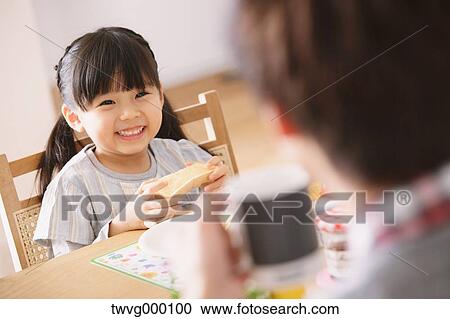 Young adult father and daughter smiling at each other while having breakfast View Large Photo Image Stock Image - Young adult father and daughter smiling at each other while having breakfast. Fotosearch