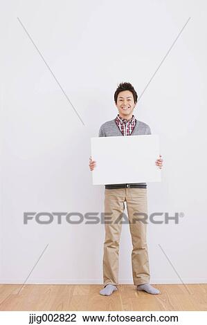Young adult man standing in front of a white wall with whiteboard View Large Photo Image Stock Image - Young adult man standing in front of a white wall with whiteboard. Fotosearch