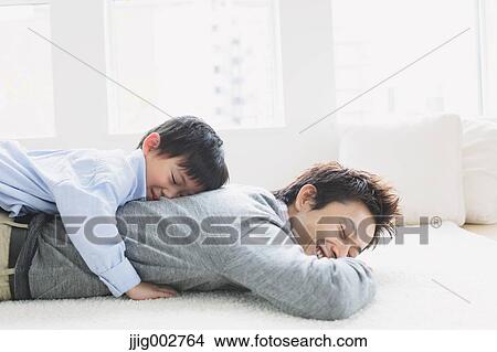 Young boy laying on his fathers back View Large Photo Image Picture - Young boy laying on his fathers back. Fotosearch
