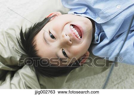 Stock Image - Young boy laying on his fathers back. Fotosearch