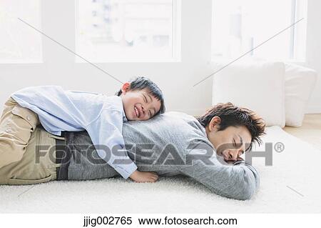 Young boy laying on his fathers back View Large Photo Image Stock Photography - Young boy laying on his fathers back. Fotosearch
