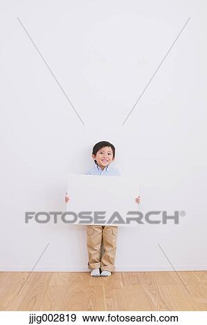 Young boy leaning against a white wall with whiteboard View Large Photo Image Stock Photo - Young boy leaning against a white wall with whiteboard. Fotosearch