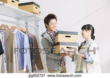 Stock Photo - Young couple choosing clothes in a walk in closet. Fotosearch
