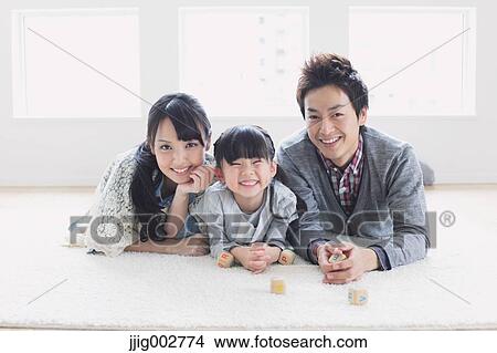 Picture - Young family laying on the floor. Fotosearch