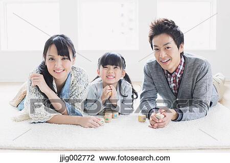 Young family laying on the floor View Large Photo Image Stock Image - Young family laying on the floor. Fotosearch