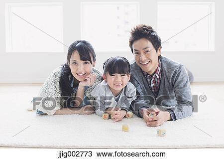 Young family laying on the floor View Large Photo Image Stock Image - Young family laying on the floor. Fotosearch
