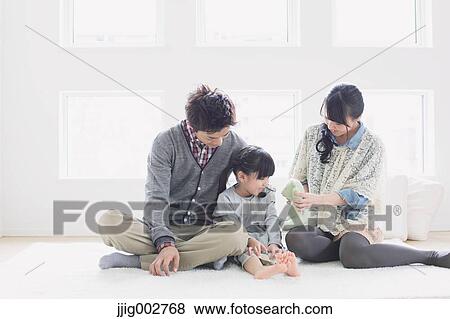 Young family laying on the floor View Large Photo Image Stock Photo - Young family laying on the floor. Fotosearch