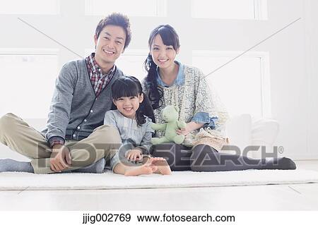 Stock Photo - Young family laying on the floor. Fotosearch