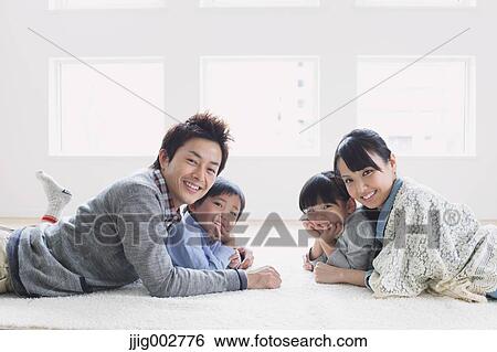 Young family laying on the floor View Large Photo Image Stock Photograph - Young family laying on the floor. Fotosearch