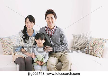 Young family relaxing on the sofa View Large Photo Image Stock Photo - Young family relaxing on the sofa. Fotosearch