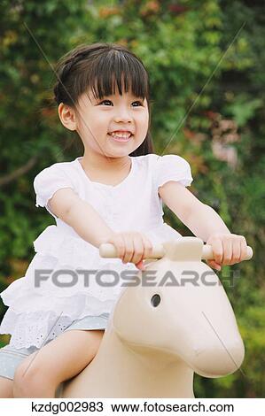 Stock Image - Young girl playing in the park. Fotosearch