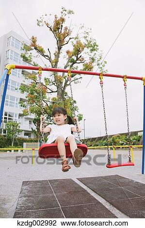 Stock Image - Young girl playing in the park. Fotosearch