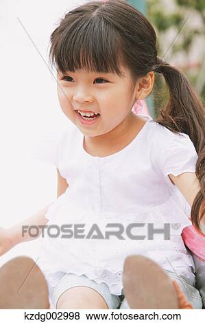 Young girl playing in the park View Large Photo Image Stock Photo - Young girl playing in the park. Fotosearch